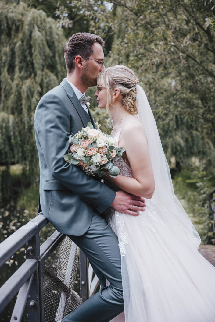 Bräutigam küsst Braut liebevoll auf die Stirn, fotografiert von Christian Roder