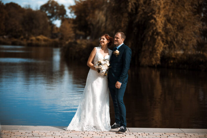 Braut und Bräutigam posieren vor ihrer Hochzeitslocation, fotografiert von Christian Roder