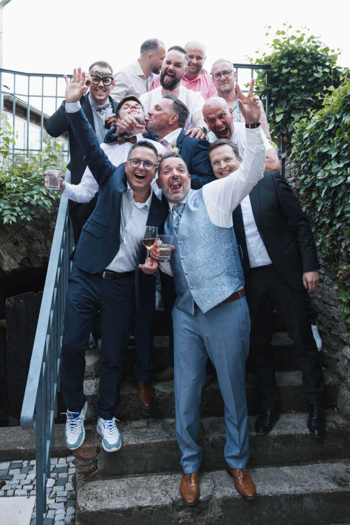 Der Bräutigam steht mit seinen Freunden oder Trauzeugen im Anzug zusammen – fotografiert von Christian Roder